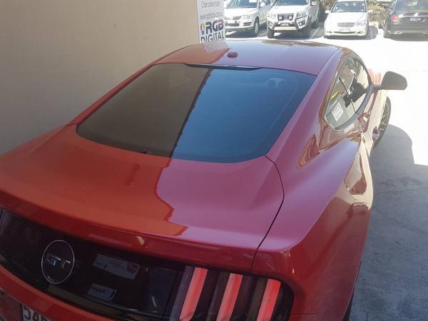 The added detail of dark window tint on this red Mustang really ties into the black trim on the vehicle